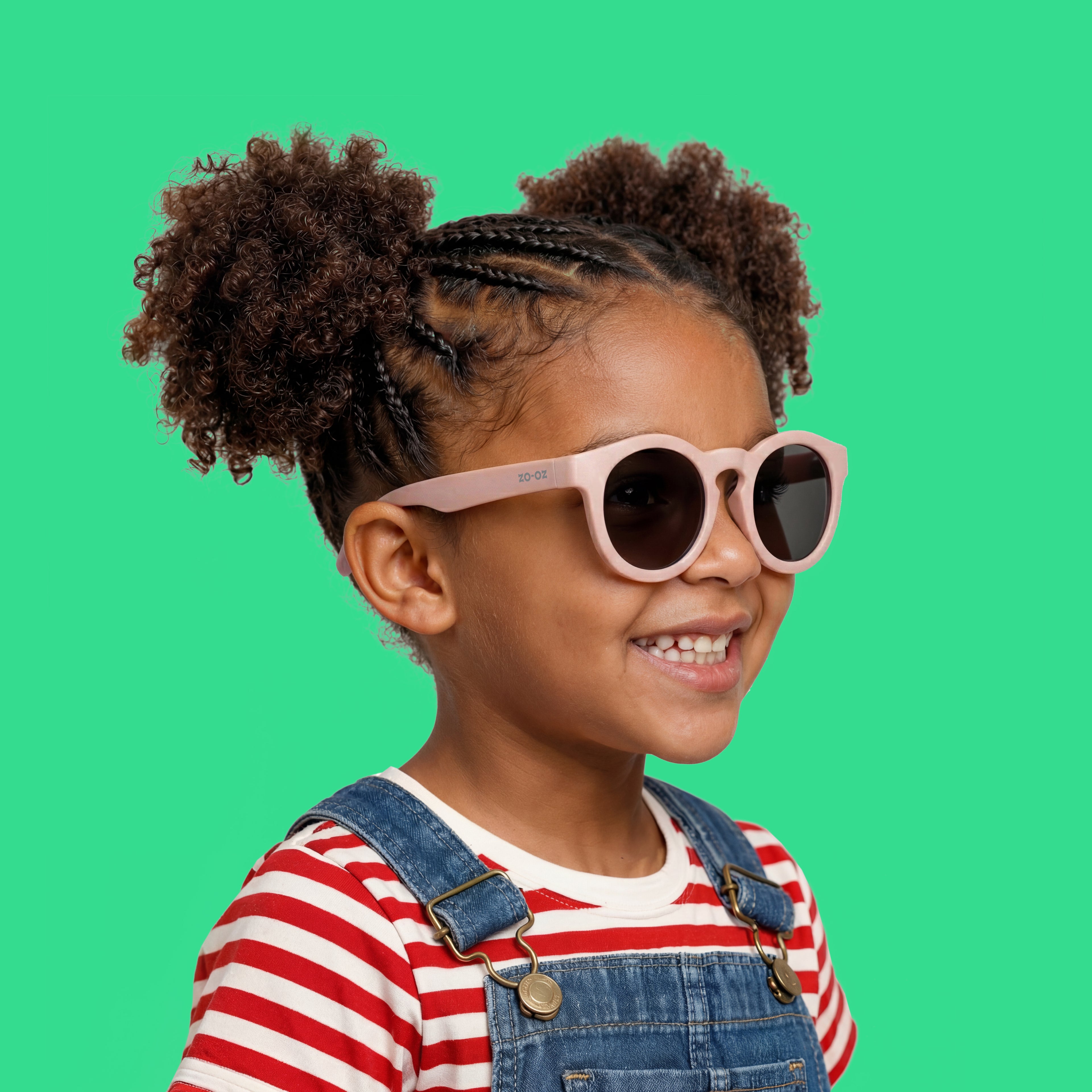 Bambina che indossa gli occhiali da sole rosa modello Beep di zo-oz montatura stile Pantos. Vista laterale che mostra come calzano sul viso nella fascia 3-5 anni.