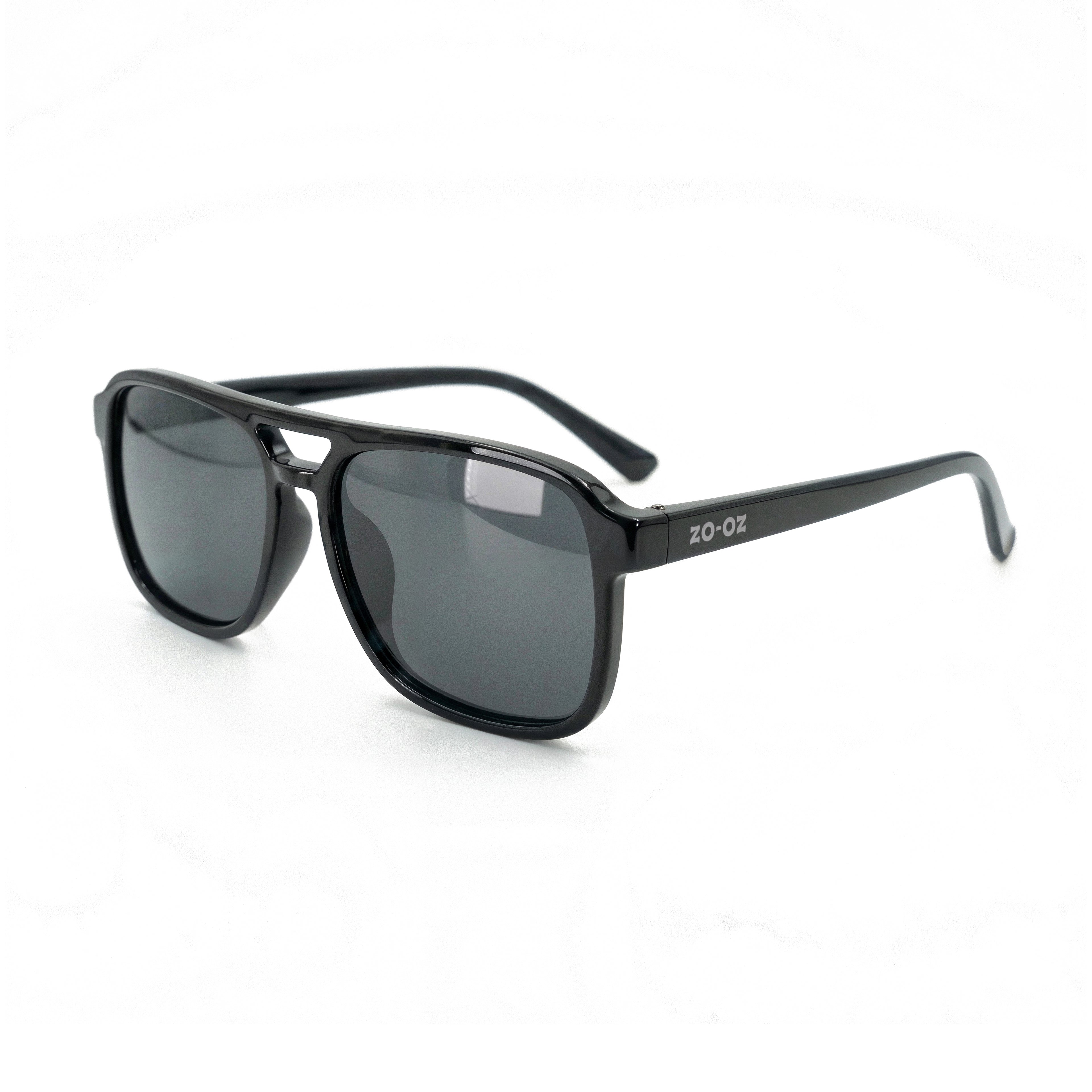 Occhiali da sole zo-oz stile aviator modello Hop nero lucido per bambini 6-12 anni. Inquadratura laterale in prospettiva con le aste aperte appoggiate su una superficie.