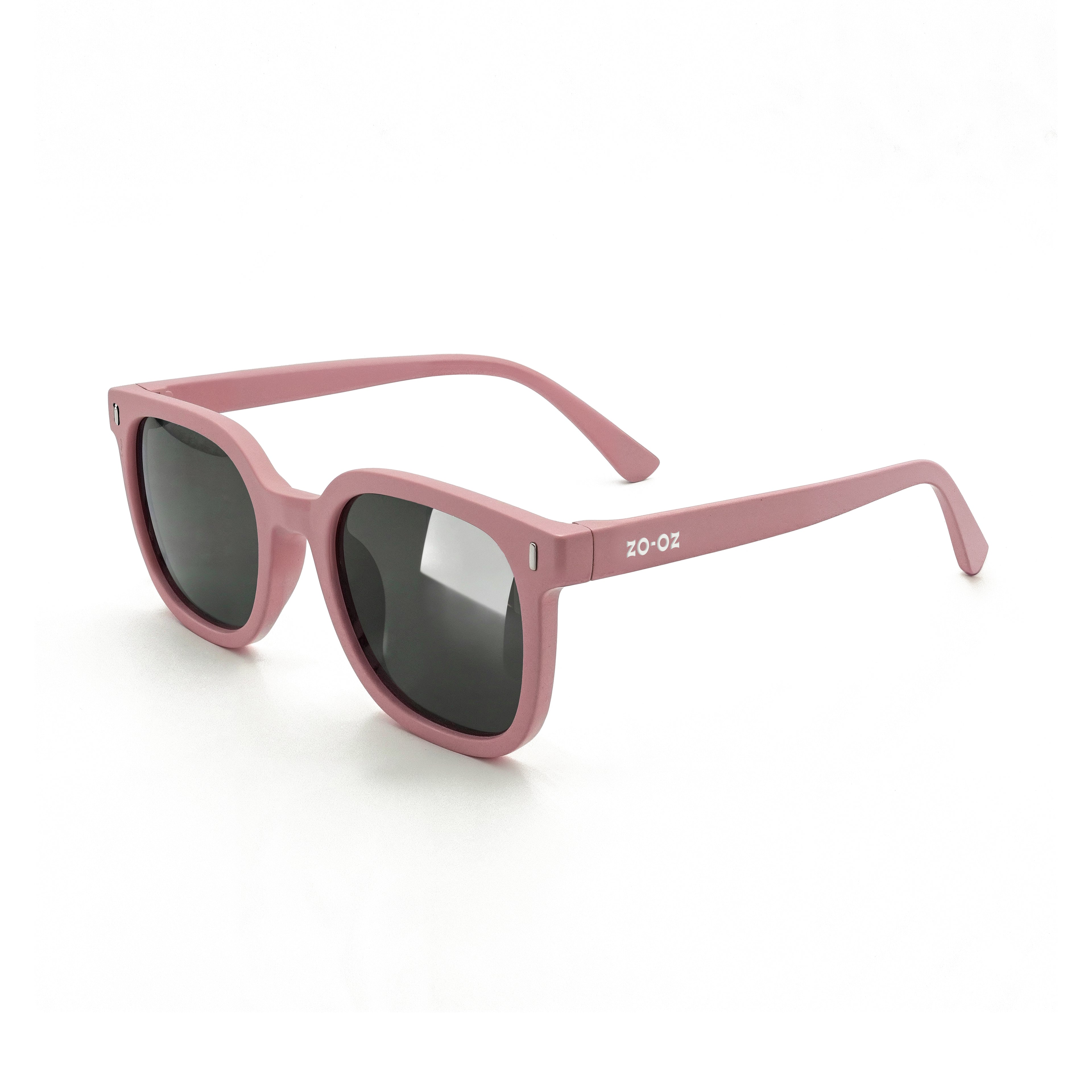 Occhiali da sole zo-oz stile wayfarer modello Zip rosa opaco per bambini 6-12 anni. Inquadratura laterale in prospettiva con le aste aperte appoggiate su una superficie.
